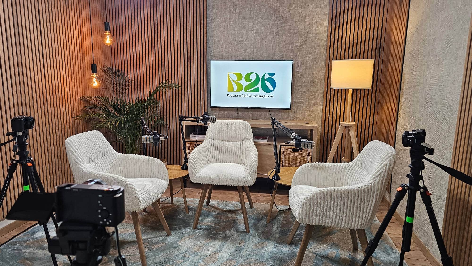 Podcastfelvételre előkészített stúdió a B26 Studióban: Røde mikrofonok, kamerák és kényelmes fotelek